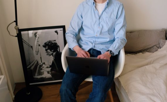 crop man using laptop in room